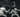 Two fencers in white gear, masks, and armed with foils