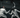 Two fencers in white gear, masks, and armed with foils