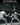Two fencers in white gear, masks, and armed with foils